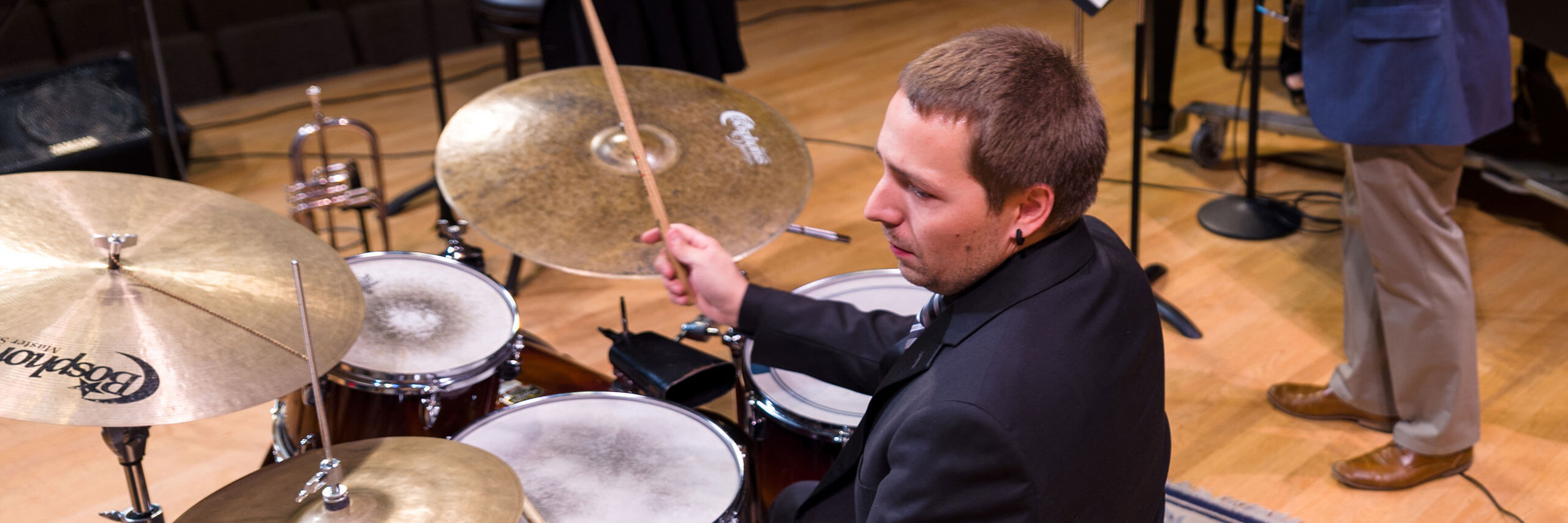 A drummer performs with the rest of the jazz band.