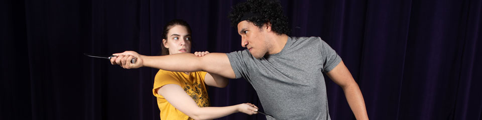 Two performers act out a combat scene.