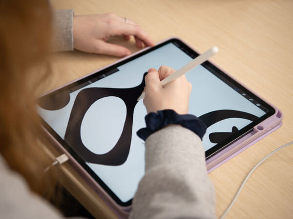 Student draws on a tablet.