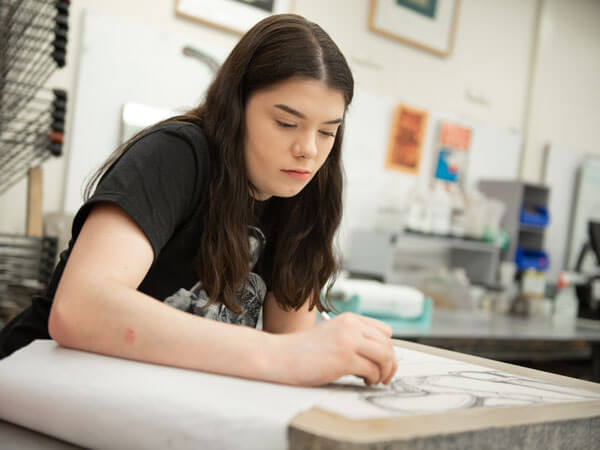 A lithography student prepares a print.