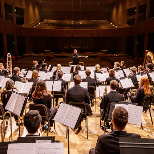 A concert band performs on stage.
