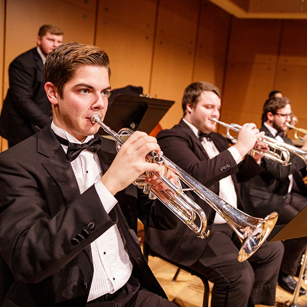 A concert band performs on stage.