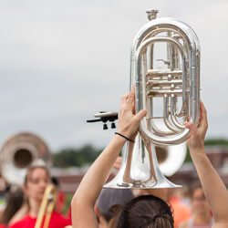 A student holds a euphonium in the air during practice.