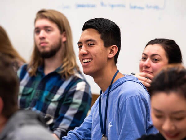 Students smile during a lecture.