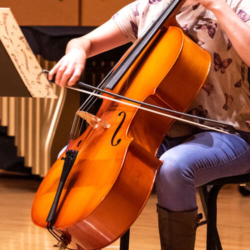 Student plays the cello in an ensemble.