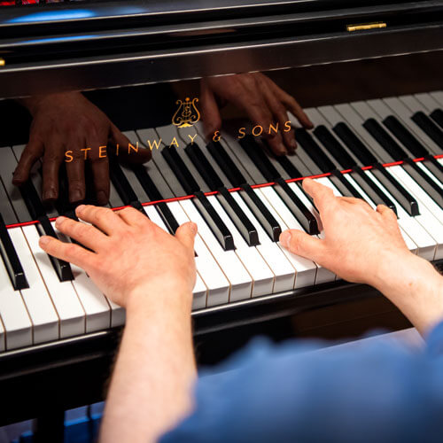 Hands lay on piano keys.