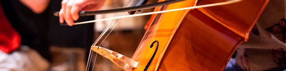 A cellist plays her cello in an ensemble.