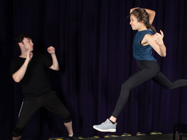 Two actors practice fighting for a production.