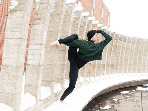 A dancer poses outside in the snow.